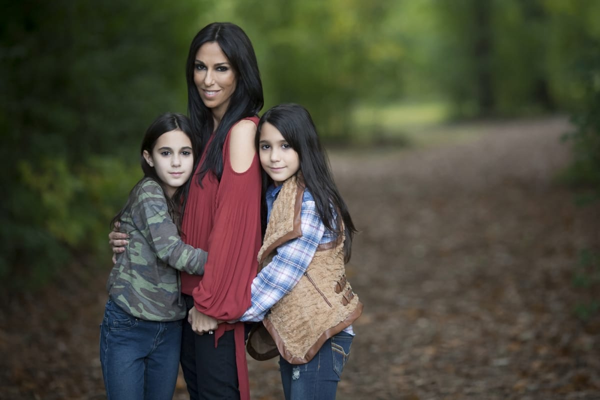 A mother stands with her two daughters while in a Detroit, Michigan forest family photoshoot