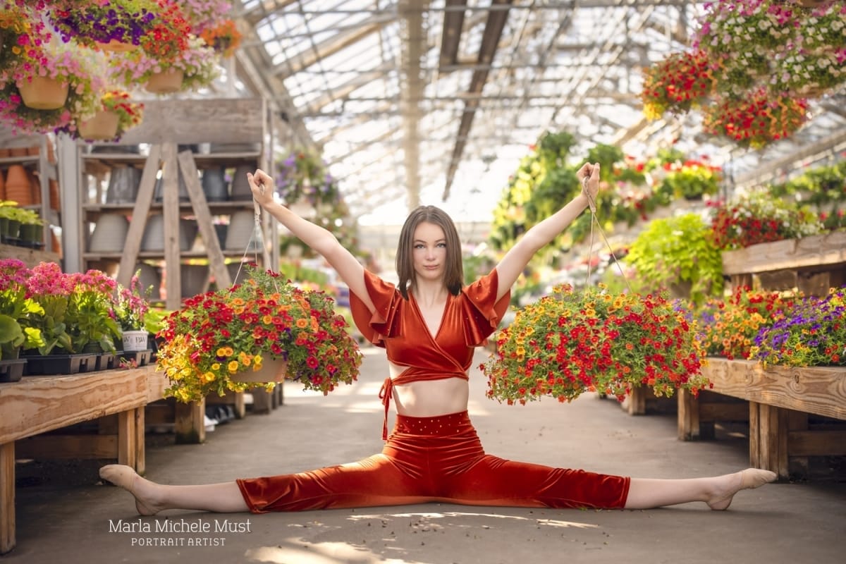 Michigan metro-area dancer's contemporary pose showcases her strength and power in a flower nursery by a skilled portrait photographer from Detroit.