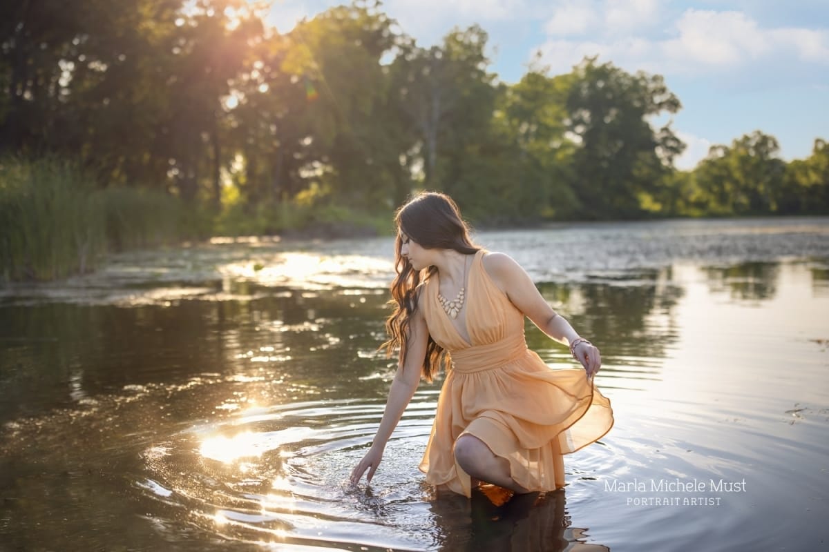 A high school senior photoshoot of a young woman making ripples in a Michigan pond