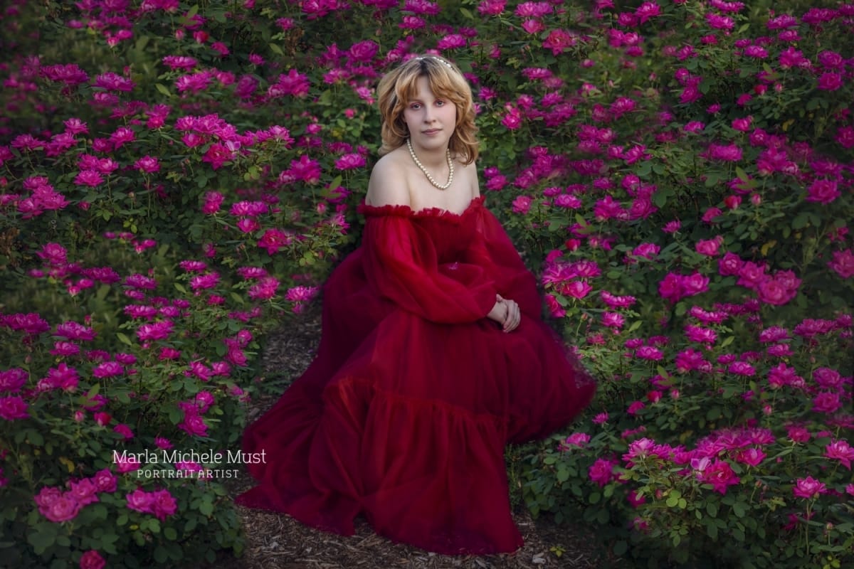 beautiful senior photo in red dress with purple flowers in Michigan woods