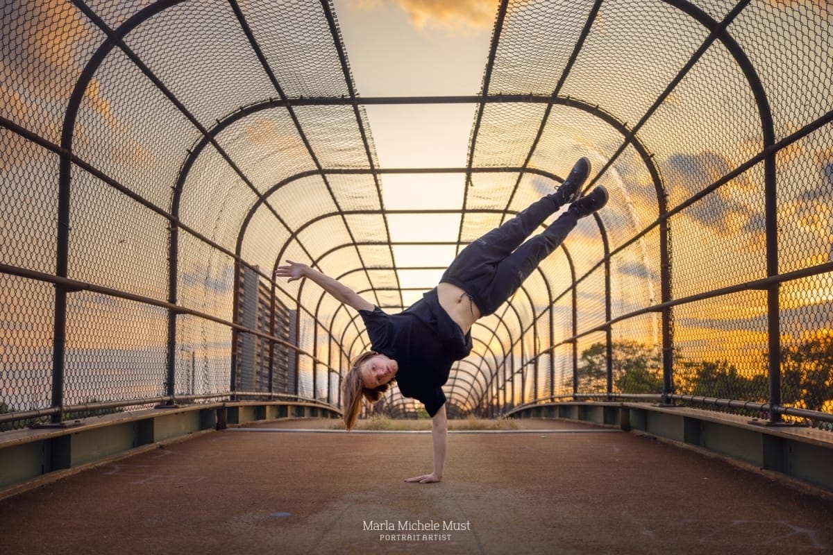 Dancer strikes a dynamic hip hop pose, exuding flair and style in a Michigan metro area cityscape at sunset..