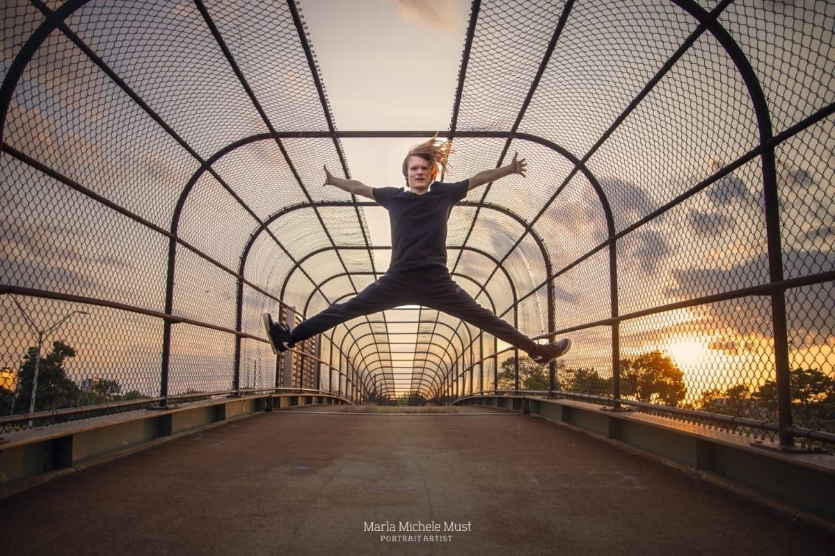 A breathtaking leap by a skilled dancer in a Michigan metro area cityscape at sunset, photographed during a dynamic photoshoot with a Detroit-based photographer.