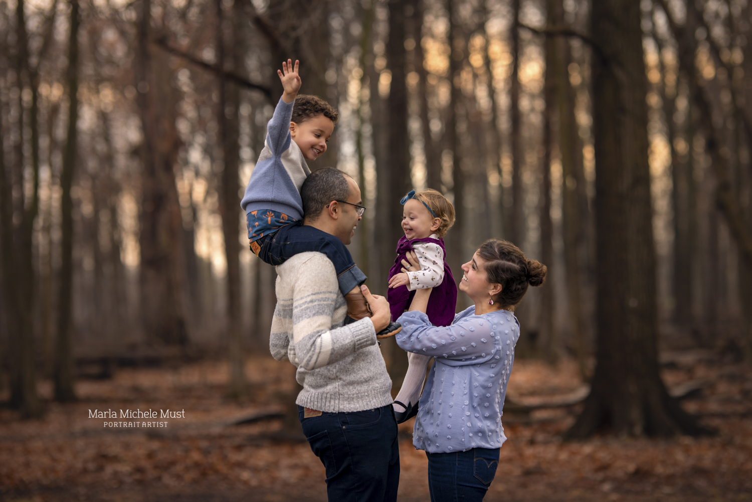 A family photoshoot near Detroit with a father holding their happy son on his shoulders and his wife holding their other toddler up to his face