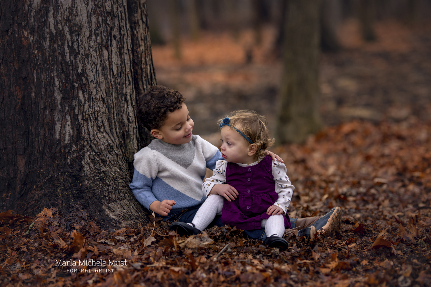 Two children pose with each other among an autumn landscape for a local Detroit family photoshoot.