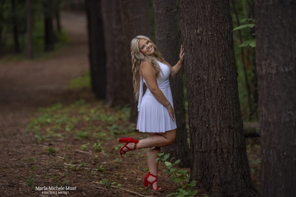 fun senior picture in Michigan park with tall trees