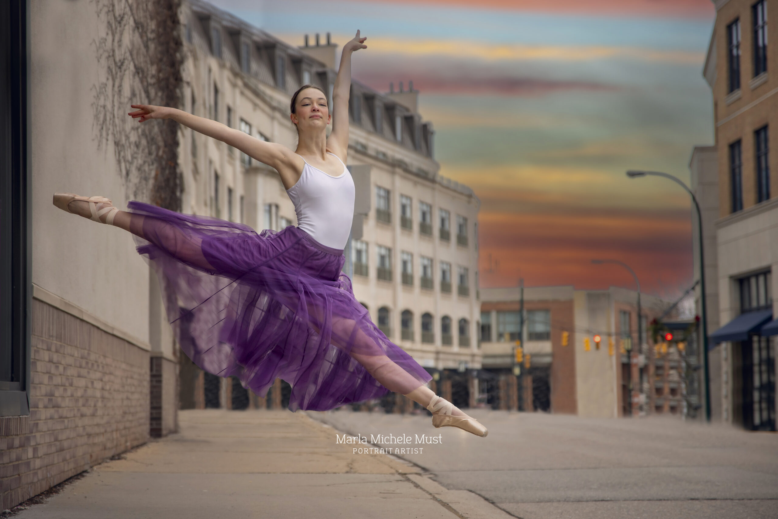 Precision and finesse are displayed by a dancer in a stunning jete, purple skirt and white tank in a city street at sunset,expertly captured by a Detroit dance photographer during a portrait session.