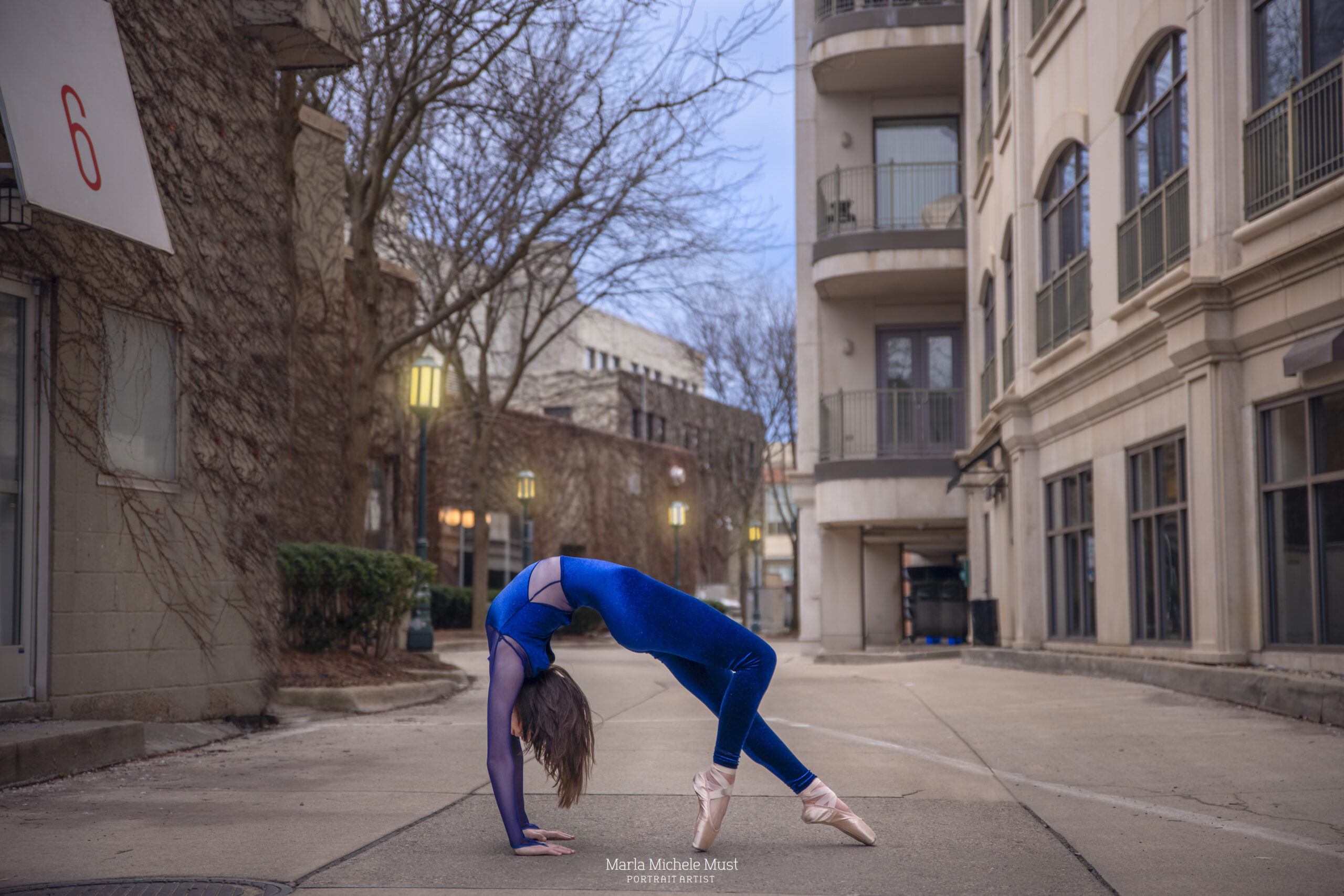 Detroit-based dance photoshoot of a ballerina wearing vibrant blue and pointe shoes effortlessly bent over backwards in a display of skill, captured by Detroit dance photographer.