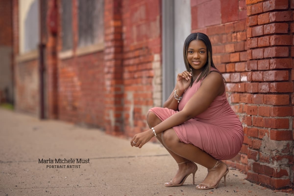 Senior photo in Detroit with brick building taken by a skilled Michigan-based photographer