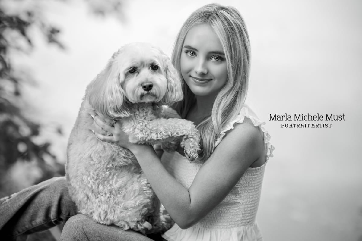 Portrait of a high school senior holding a fluffy dog - Black and white photo for a senior portrait photoshoot