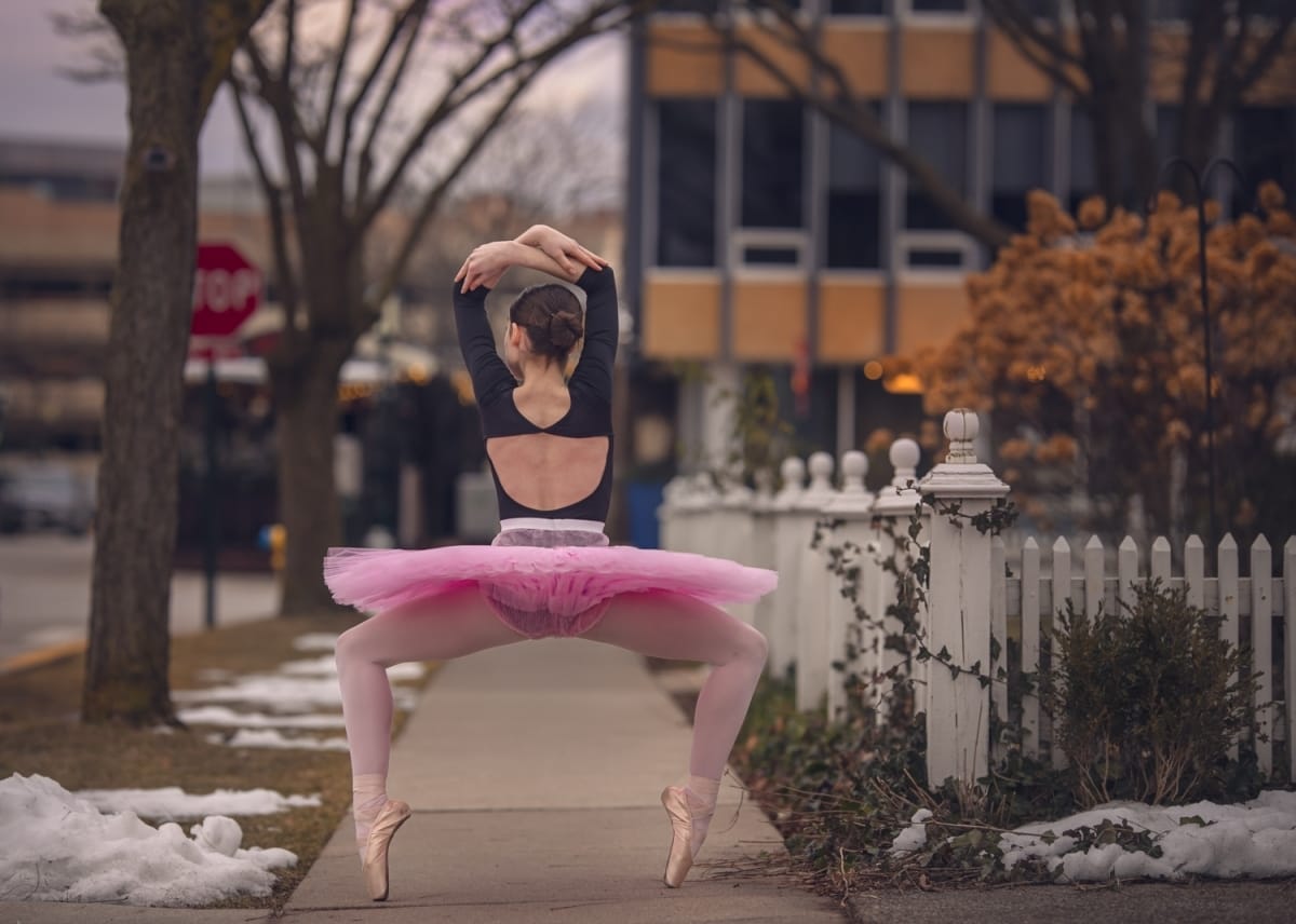 A Detroit dancer in a pink tutu has her back to the camera as she displays a plie squat en point in a Michigan dance photoshoot.