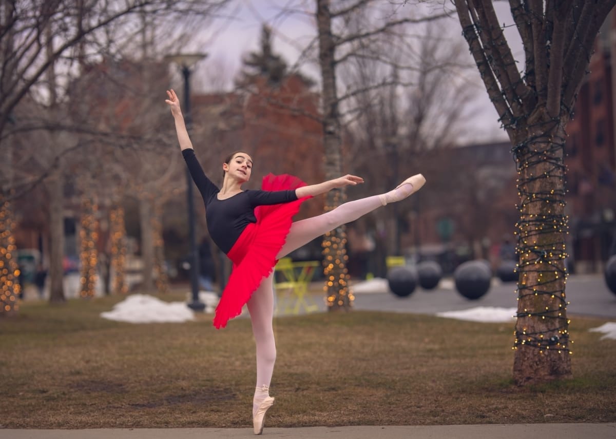 A red tutu-wearing dancer's arabesque is flawlessly captured by a skilled portrait photographer from Detroit.