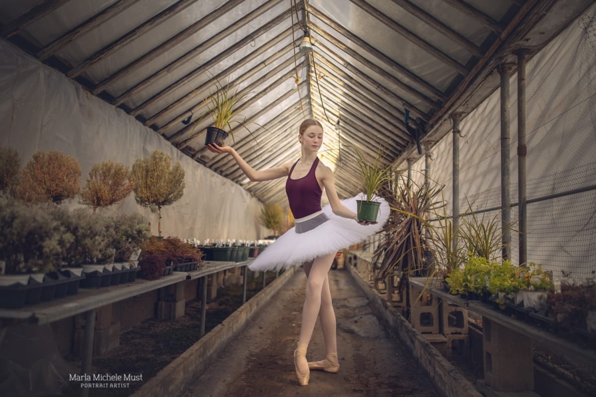 Dancer poses in a standing position while holding a flower pot in each hand, captured by a Detroit-based photographer during a dance photoshoot.
