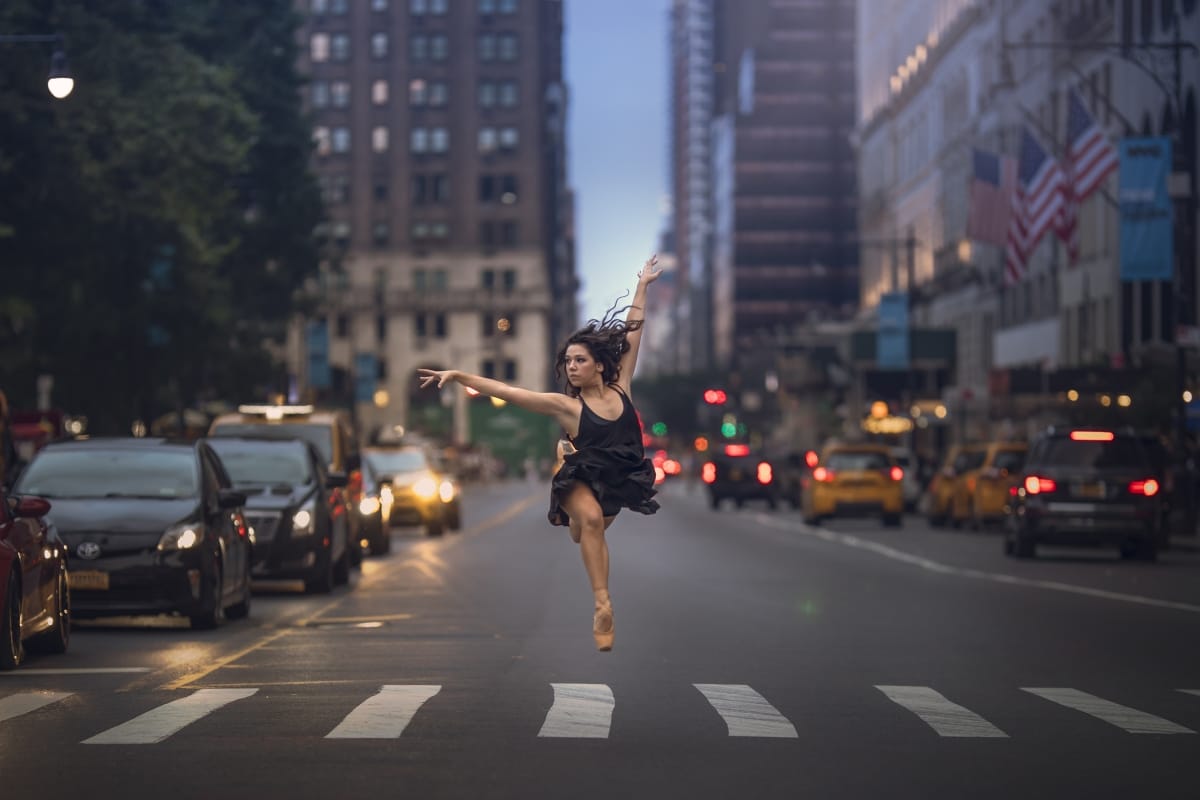 Dancer's leap is skillfully captured by a Detroit photographer during a captivating dancer photoshoot in a Michigan metro area city street at night..