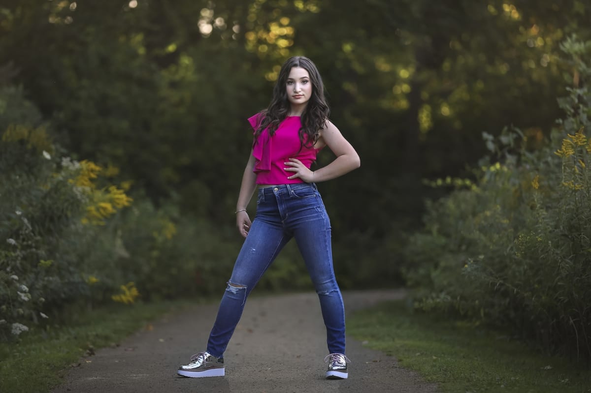Dancer stands confidently with on hand on her hip, starting directly at the camera, exuding confidence and power during a Detroit-based dance photoshoot.