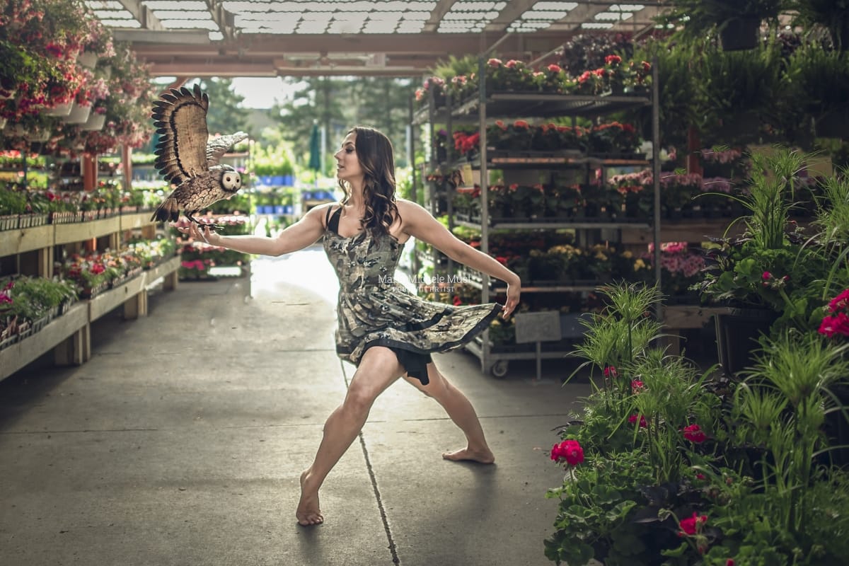 Dancer's lyrical pose shines in this captivating image from a dancer photoshoot with a talented Detroit photographer in a Michigan flower nursery.