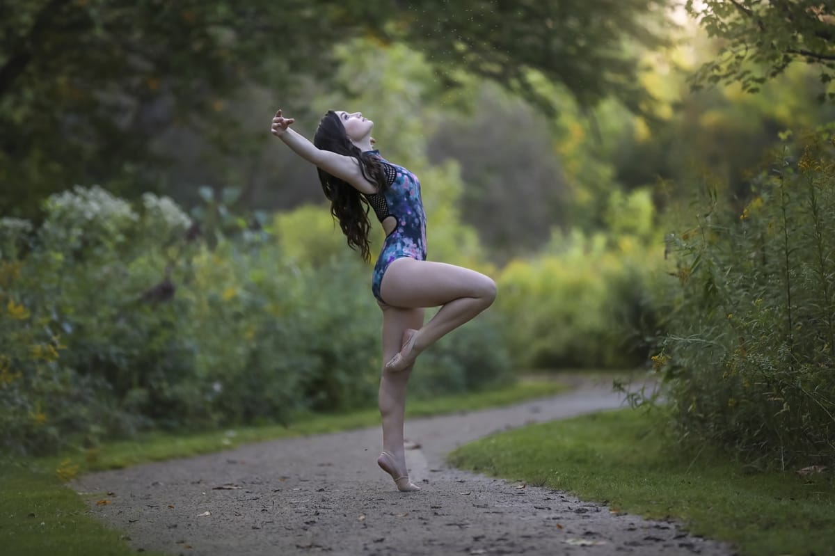 Dancer's lyrical pose shines in this captivating image from a dancer photoshoot with a talented Detroit photographer on a Michigan metro-area trail.