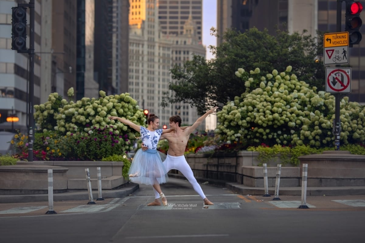 Classically-trained dance partners pose in a lush city garden during a dancer photoshoot captured by a Detroit-based photographer.