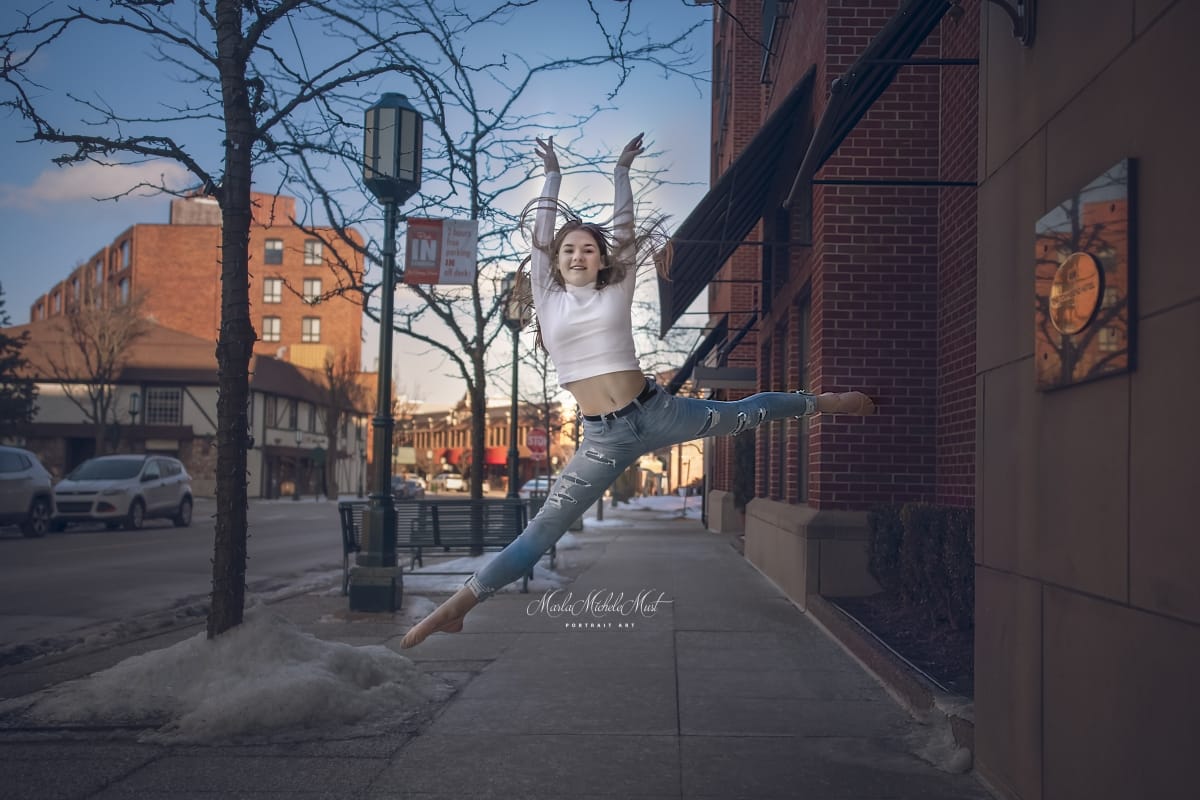 Casually-dressed dancer's leap is skillfully captured by a Detroit photographer during a captivating dancer photoshoot in a Michigan metro area.