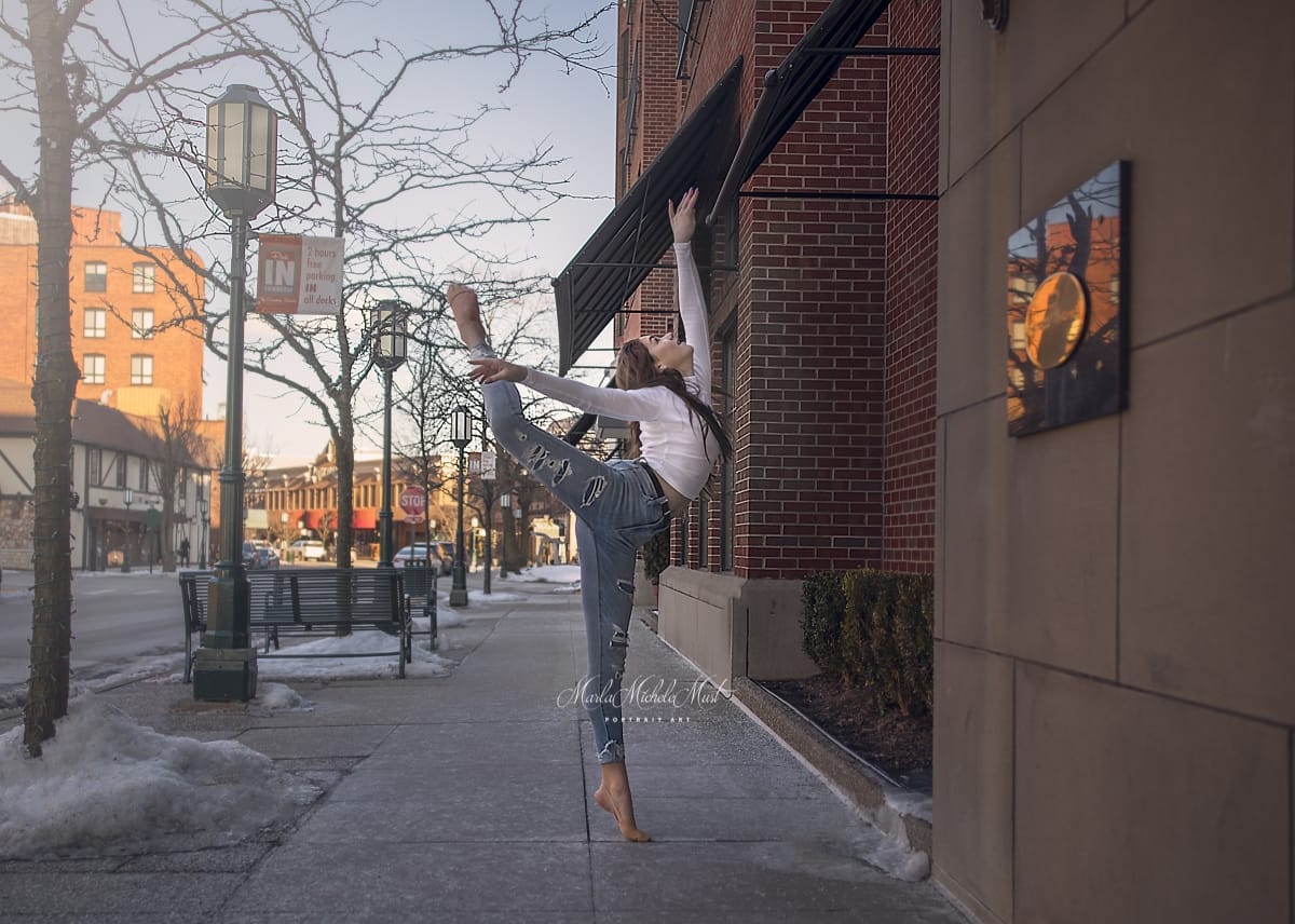 Dancer's leg and arm extensions through her light blue dress shine in this stunning dance portrait, captured by a talented Detroit photographer on a city sidewalk..