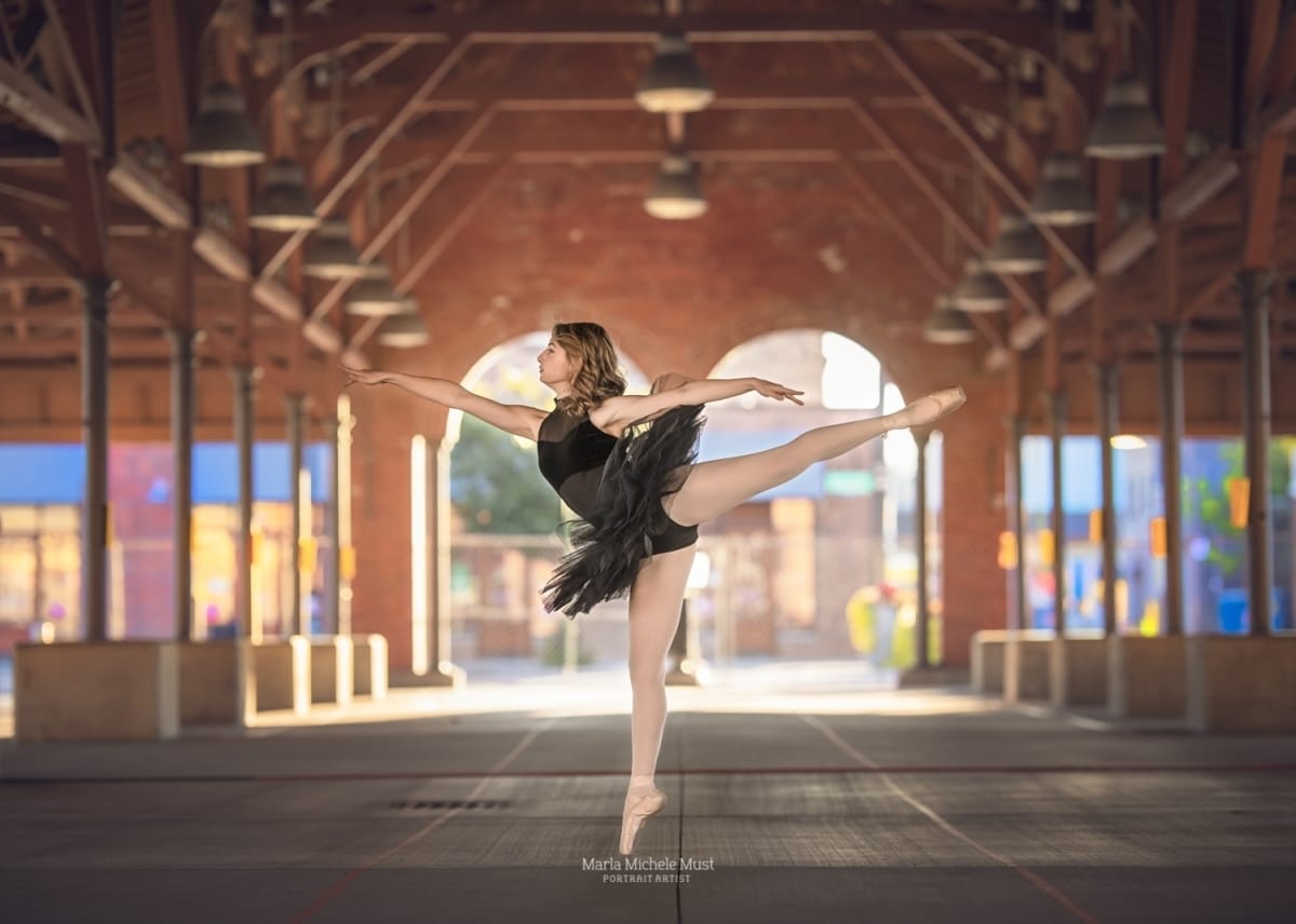 Senior picture taken of a ballerina gracefully posting in an empty space in Detroit's urban epicenter