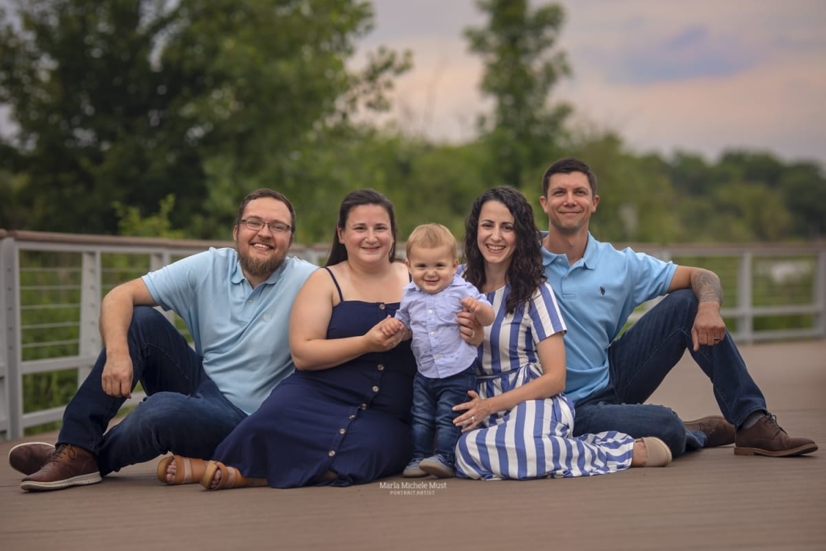 family wearing blue pose for a local Detroit photographer on a trail