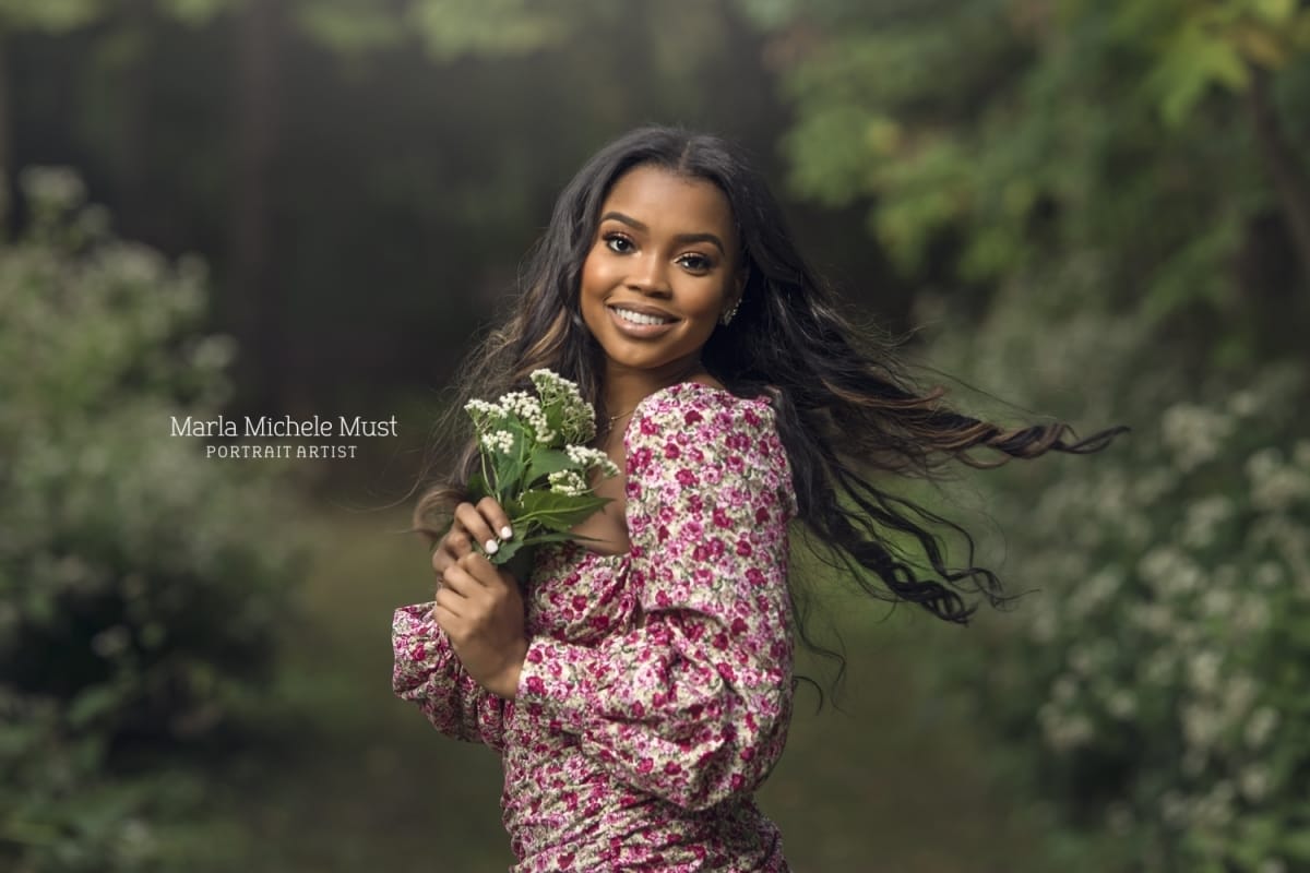 Detroit-area High school senior photo of a girl holding a bouquet of flowers as she twirls and smiles at the camera