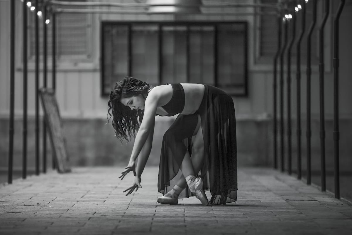 A dance portrait taken in black and white of a woman bent over in a contemporary pose, captured by Michigan dance photographer.
