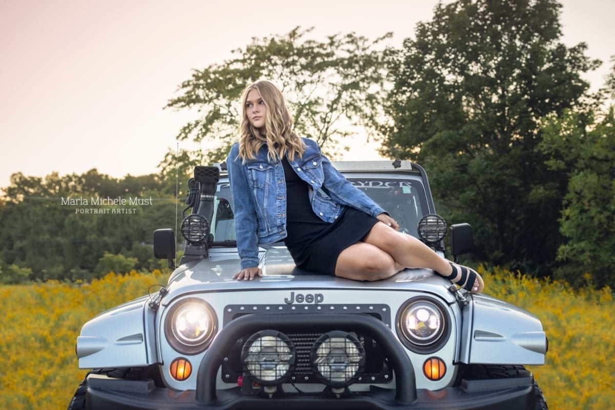 Detroit-area High school senior photographer captures the portrait of a girl sitting on the hood of her jeep