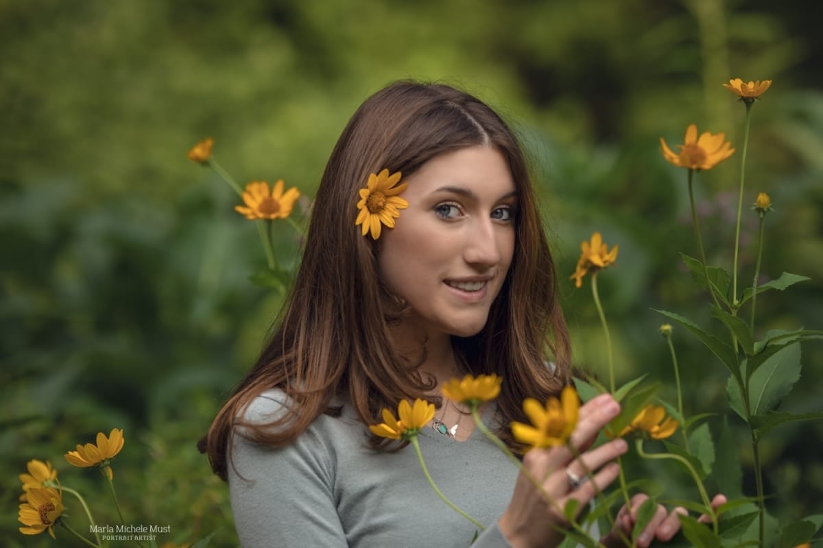 High school senior poses with flowers in her hand for her high school senior portrait photoshoot in Detroit