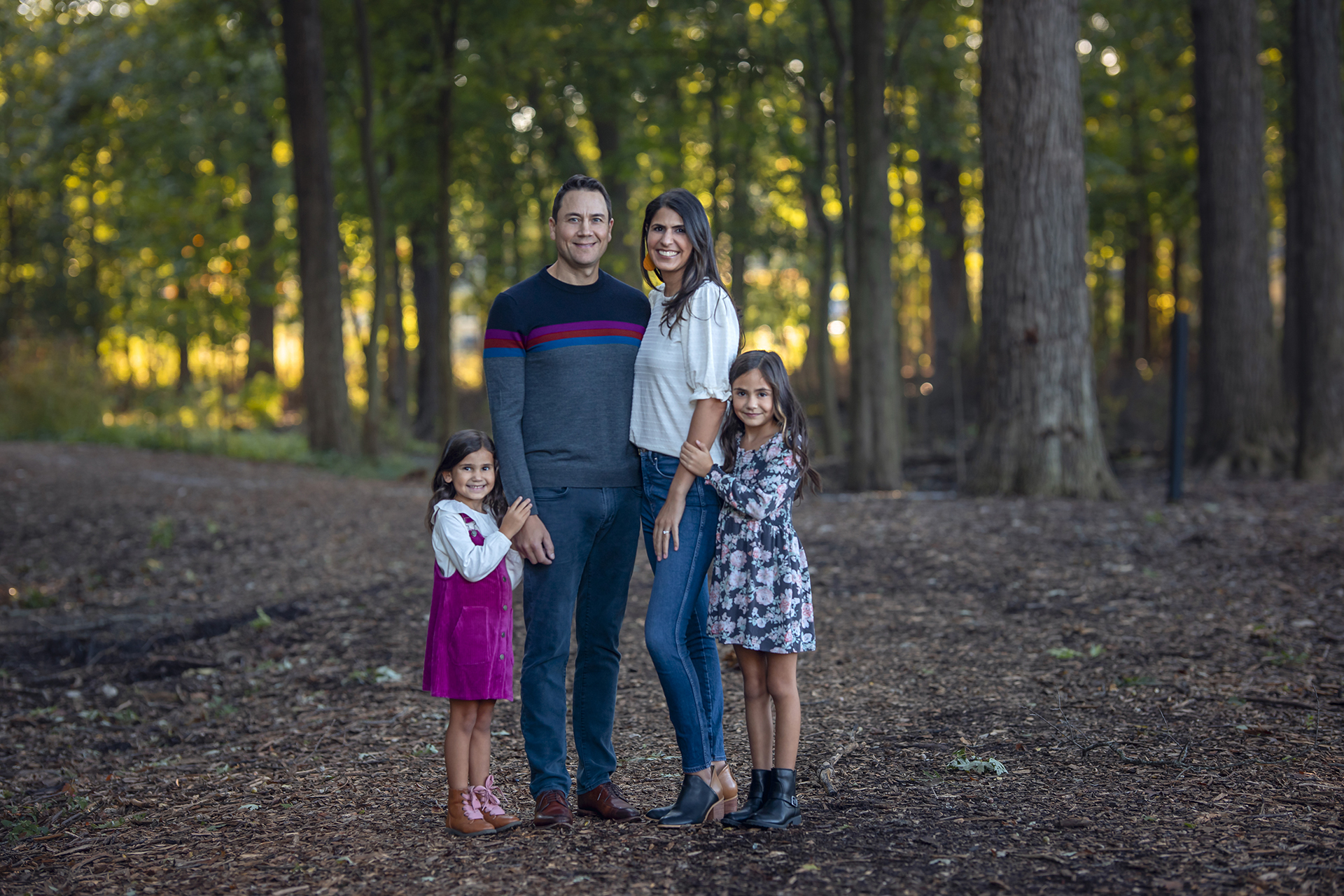 A couple stand with their two children for a family photoshoot in the forests near Detroit.